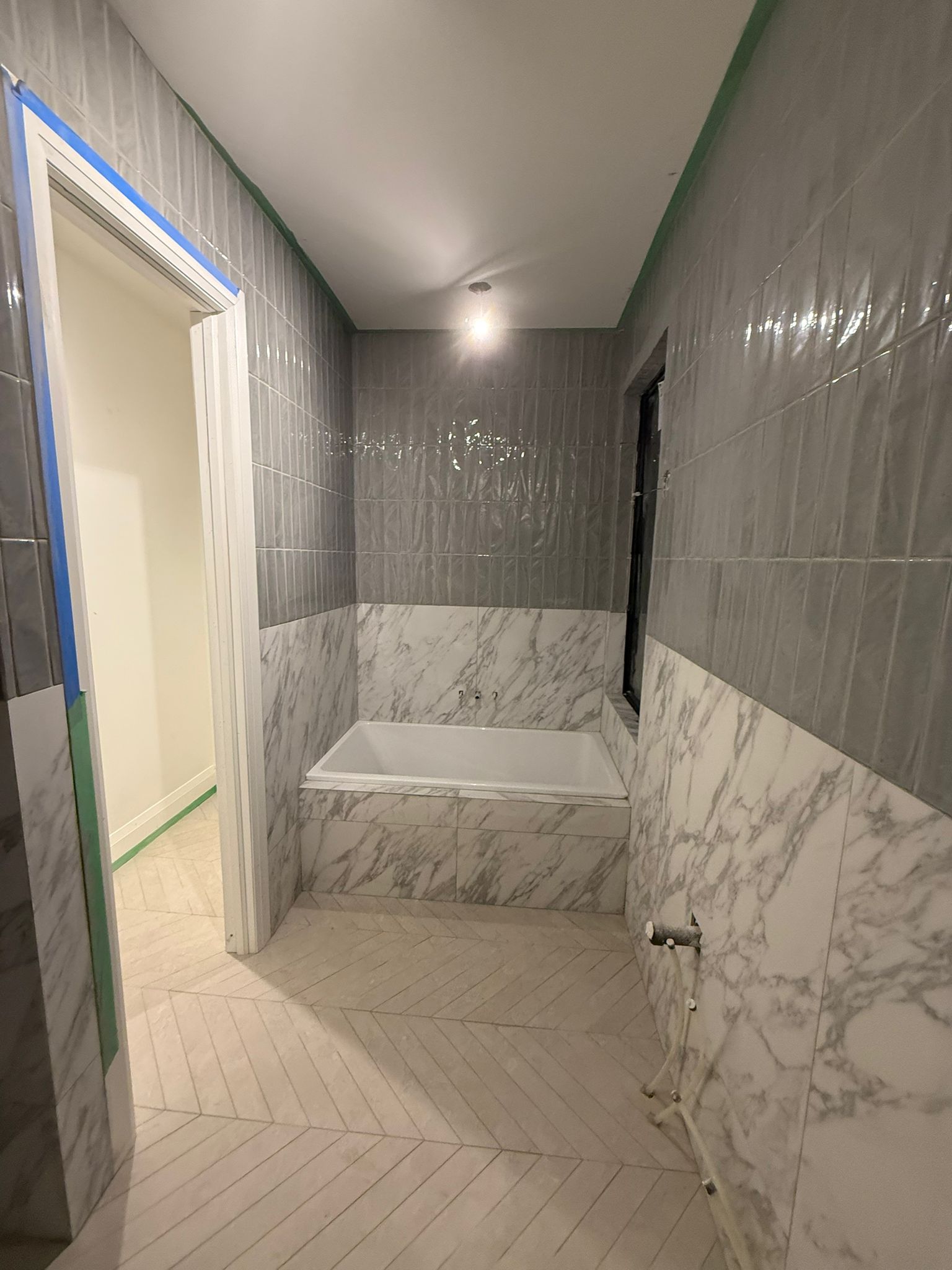 Washroom tile renovation with marble-look tile and gray wall tile